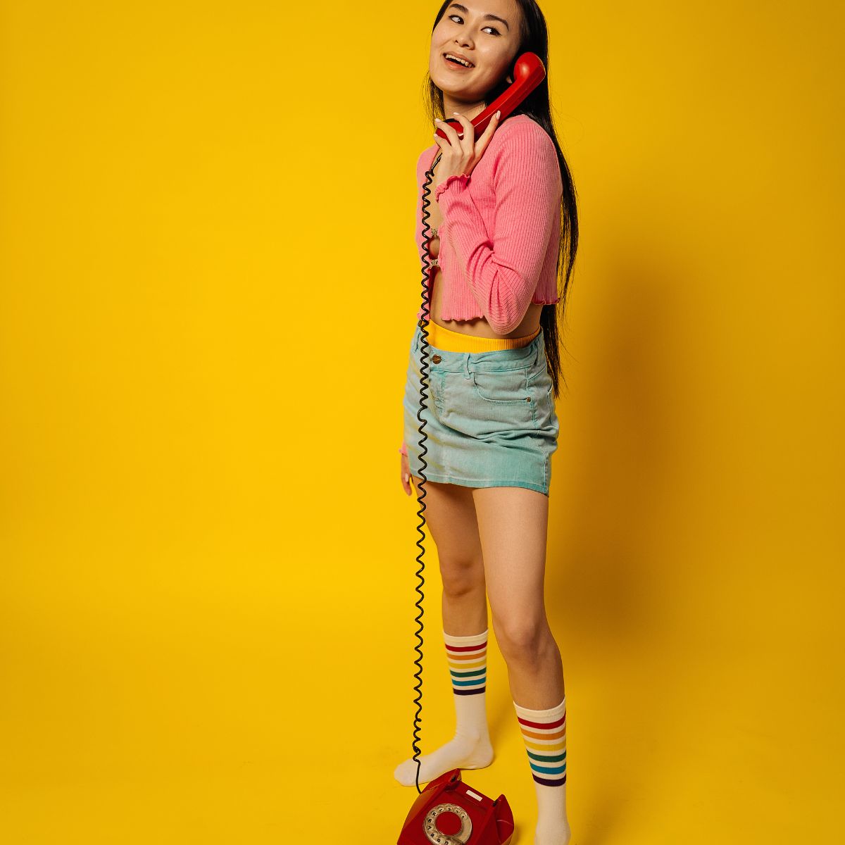 A person holding a phone whilst wearing a pair of colourful socks.